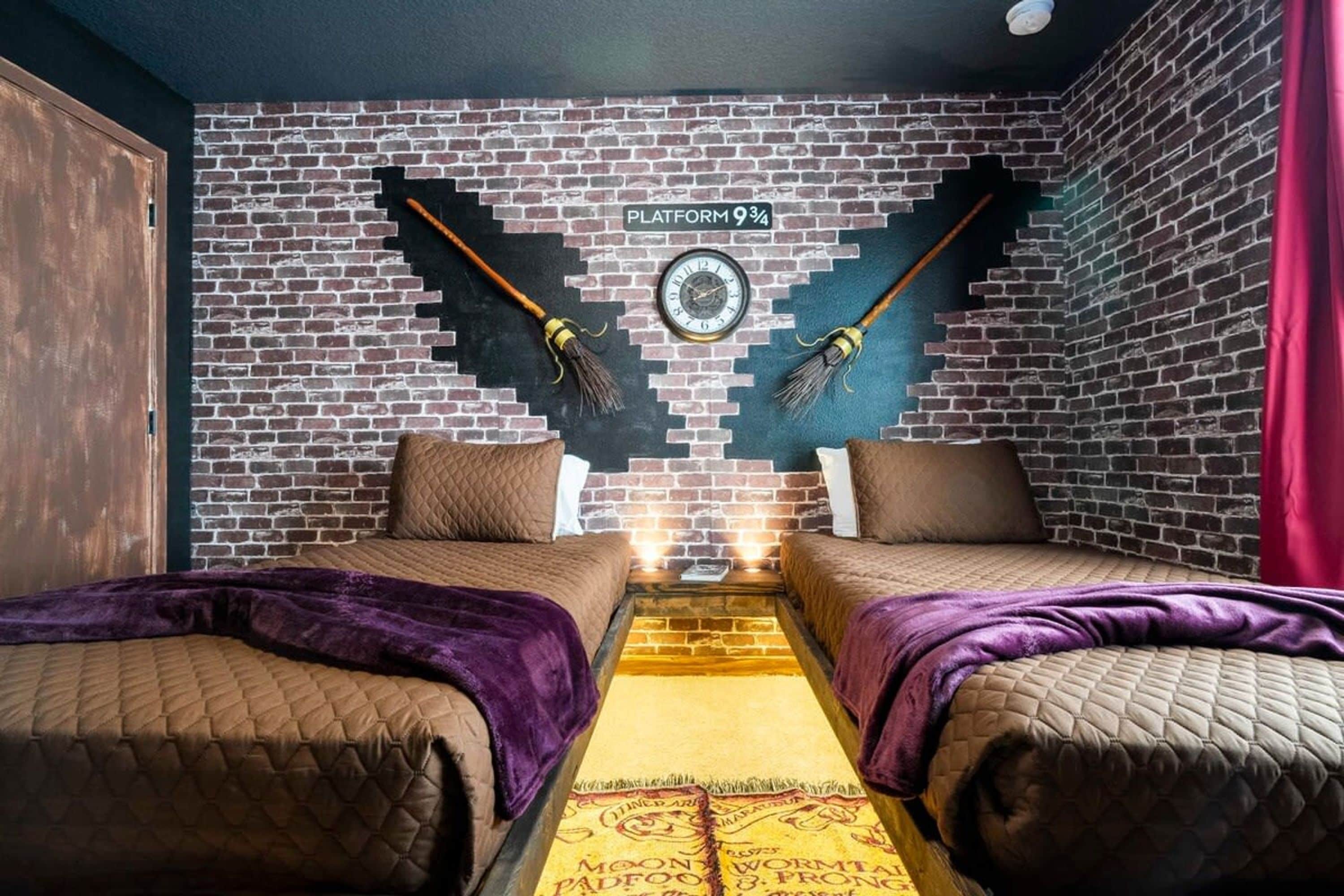 A room with two beds, a brick wall, a clock, and a sign reading "PLATFORM 9¾".