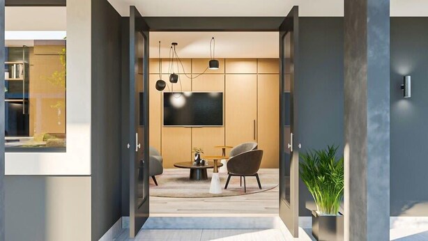 A modern living room with a flat-screen TV, a round coffee table, and two chairs.