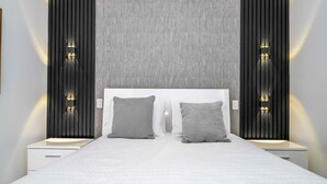Ein modernes Schlafzimmer mit einem großen Bett, zwei Nachttischen und Wandleuchten.