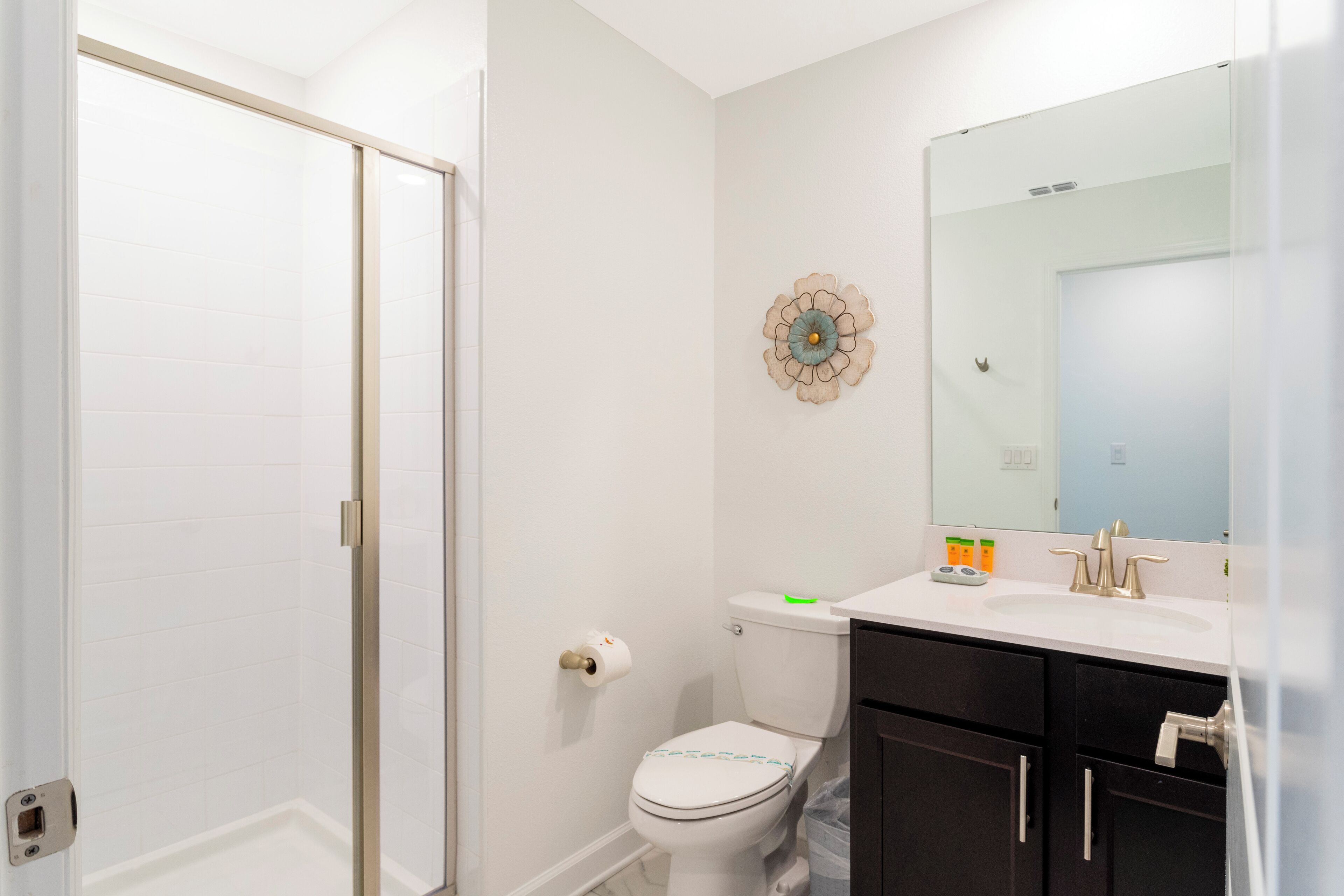 A bathroom with a toilet, sink, and mirror.
