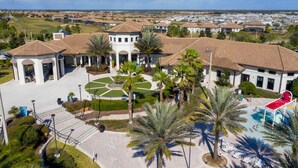 A resort with a central courtyard, palm trees, and a pool area. - Fabulous 5 Bedrooms Close to Disney at Champions Gate Resort 8988 (Kissimmee)