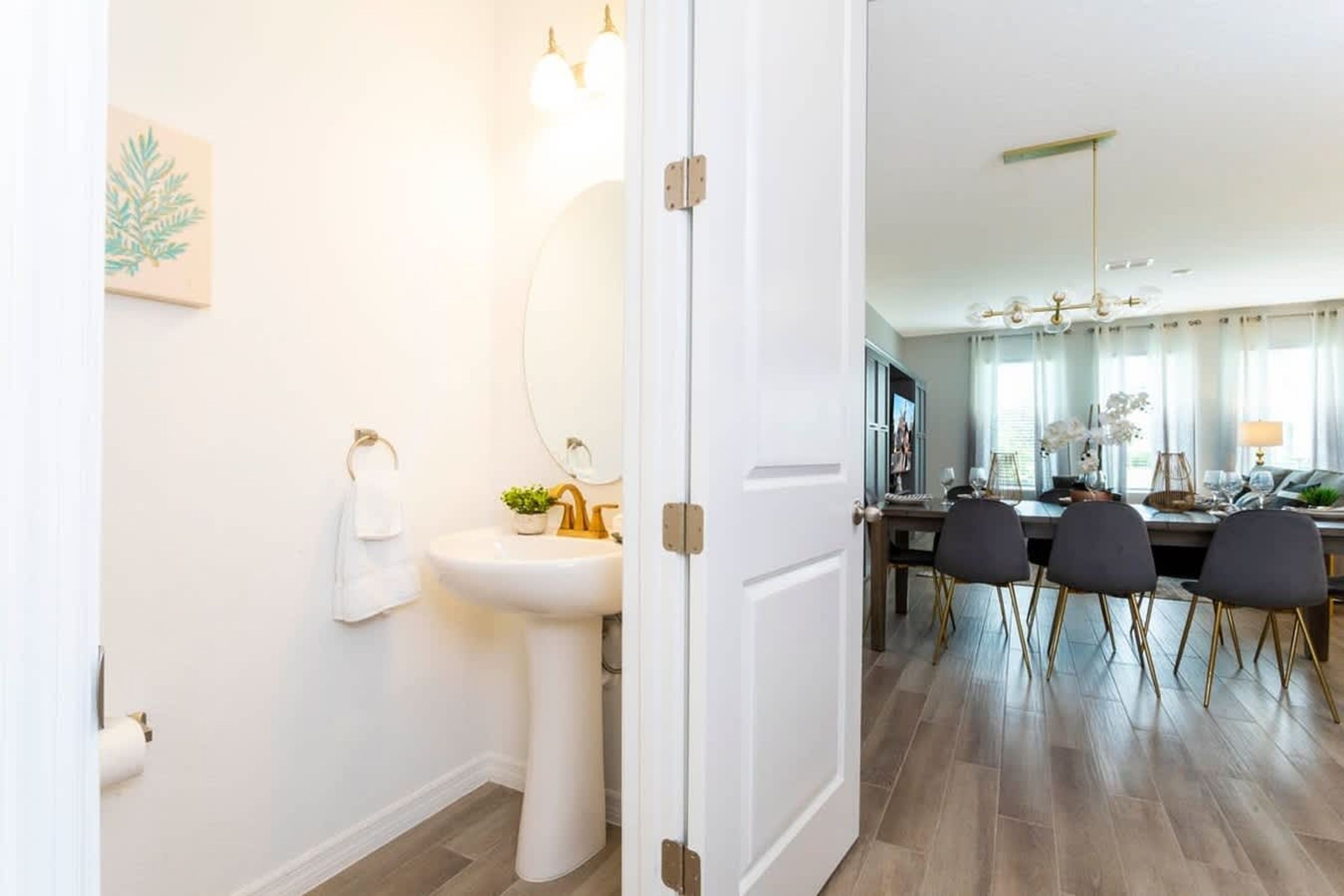 Et moderne badeværelse med vask, toilet og spejl.