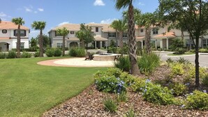 A residential area with multiple two-story houses, a well-maintained lawn, and a circular patio area. - 5 Bedroom at Storey Lake Orlando FL Close to Disney 4851 (Kissimmee)