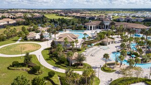 Een resort met meerdere zwembaden, een golfbaan en een verzorgd landschap.