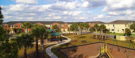 A residential area with houses, a playground, and a stop sign.