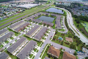 An aerial view of a residential area with multiple apartment buildings, roads, and a large body of water. - Family Friendly 4 Bedroom Close to Disney in Orlando Area 5126a (Kissimmee)