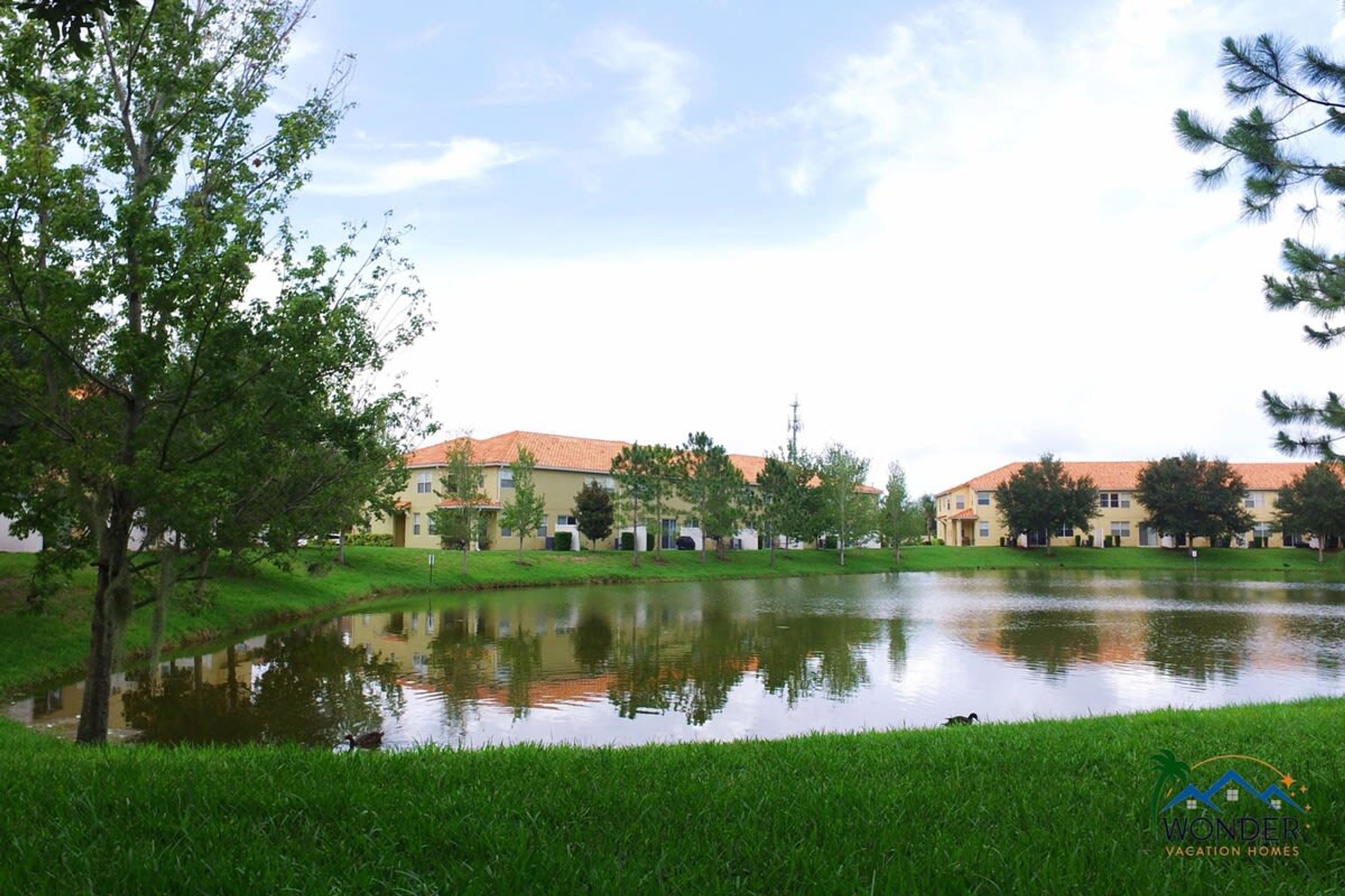 A residential area with houses and a pond.
