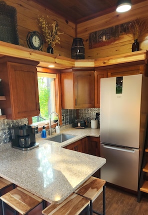 Fully equipped kitchen with a refrigerator, coffee maker, and ample counter space.