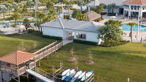 A waterfront property with a dock, a pool, and a small building. - Family Friendly Four Bd w Pool at Storey Lake Resort 5035 (Kissimmee)