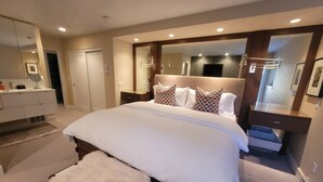 A modern bedroom with a large bed, a bedside table, a mirror, and a wardrobe. - The Springs - Steps from Warm Springs Base (Ketchum)
