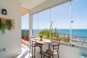 Un balcón con una mesa para dos, con vistas al mar.
