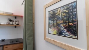 Een lijst met een schilderij van een bospad aan de muur.