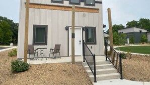 A modern two-story building with a flat roof, large windows, and a front door.