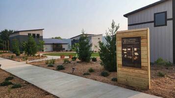 A modern building complex with a wooden sign indicating 'Bluffside Gardens' and a parking map.