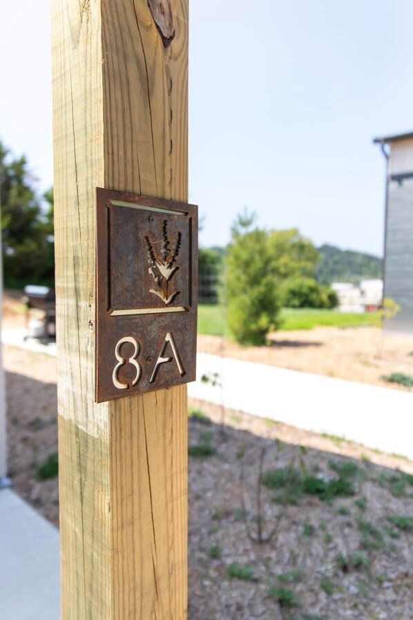 A wooden post with a metal plaque displaying a bird symbol and the number 8A.