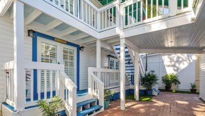 A multi-level house with a covered patio area, multiple staircases, and potted plants. - Custom House Inn (Key West)