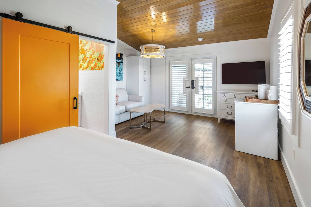 Une chambre à coucher avec un lit, un bureau, une chaise et un téléviseur.