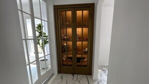 A hallway with a glass door leading to a room with a marble floor and a cabinet with glass doors. - Perfect for family/corporate, Strategic location, 2mi Yale, 2.8 mi Airport,  (New Haven)