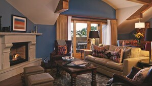 A cozy living room with a fireplace, comfortable seating, and a view of the outdoors. - Boutique Resort in Vail Village -  3 BR - 3BA Residence at The Sebastian (Vail)