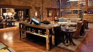 A spacious lobby with a stone wall, a central coffee table, sofas, and a fireplace. - Boutique Resort in Vail Village -  3 BR - 3BA Residence at The Sebastian (Vail)
