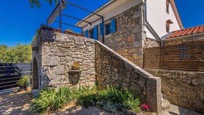 A stone house with a white facade, blue shutters, and a small staircase leading to the entrance. - Holiday house KUNTENTA with private pool and jacuzzi (Skrbčići)