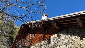 A stone building with a wooden balcony and a chimney.