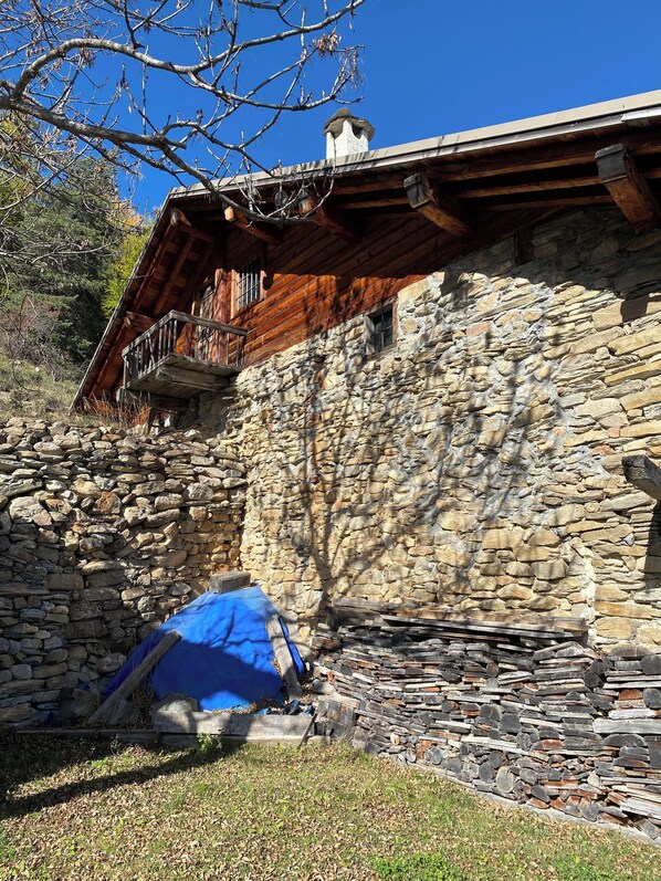 A stone building with a wooden balcony and a chimney.