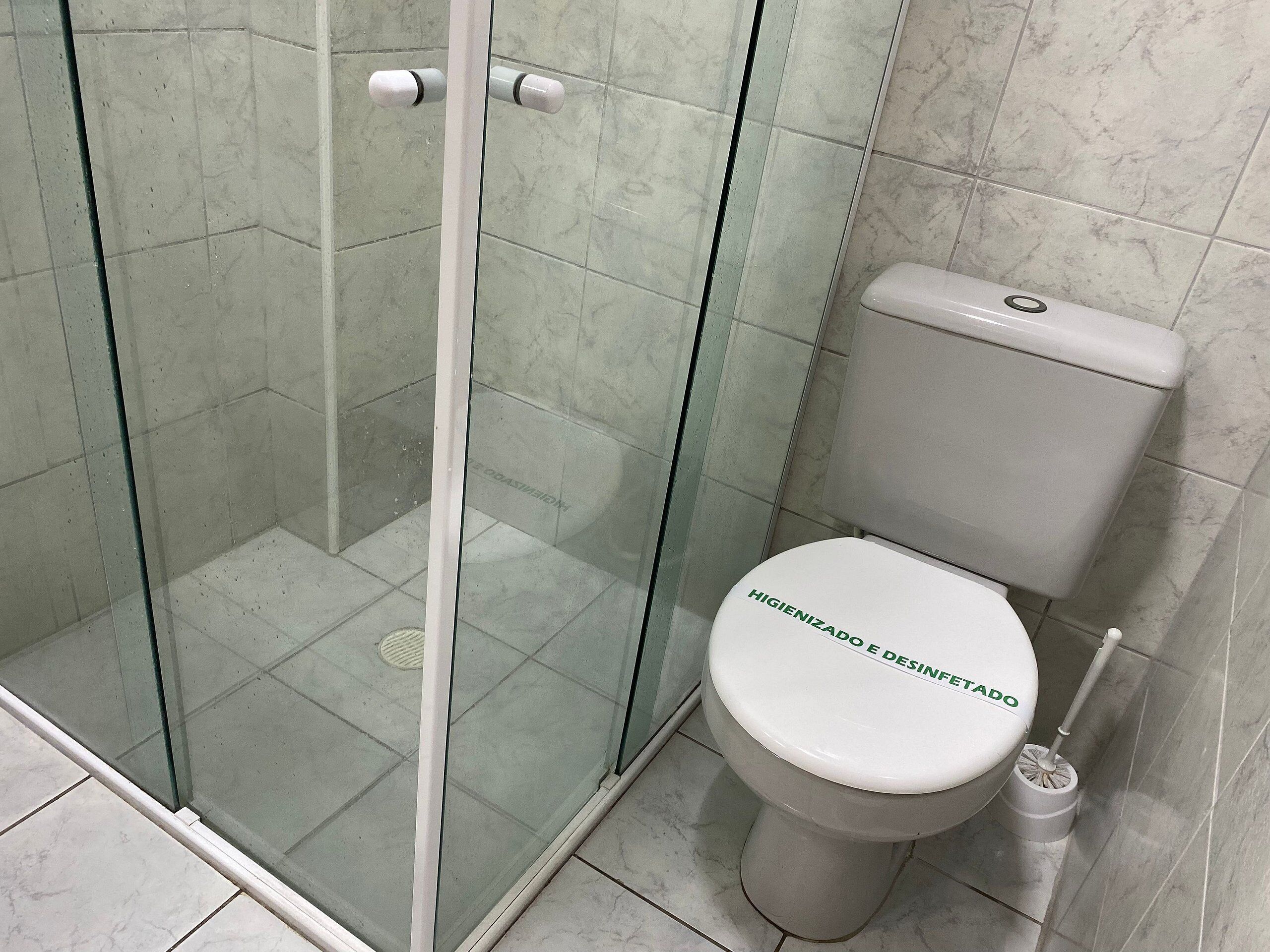 Une salle de bain dotée d’une douche à parois de verre, de toilettes et d’un bidet.