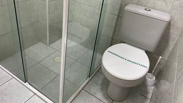 Une salle de bain dotée d’une douche à parois de verre, de toilettes et d’un bidet.