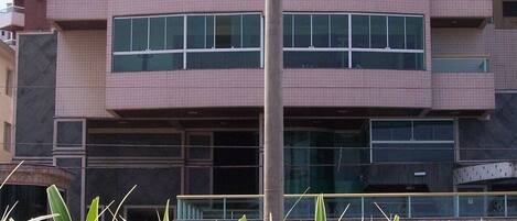 Un edificio de varios pisos con un diseño arquitectónico moderno, que presenta una columna vertical central y ventanas amplias en cada planta.