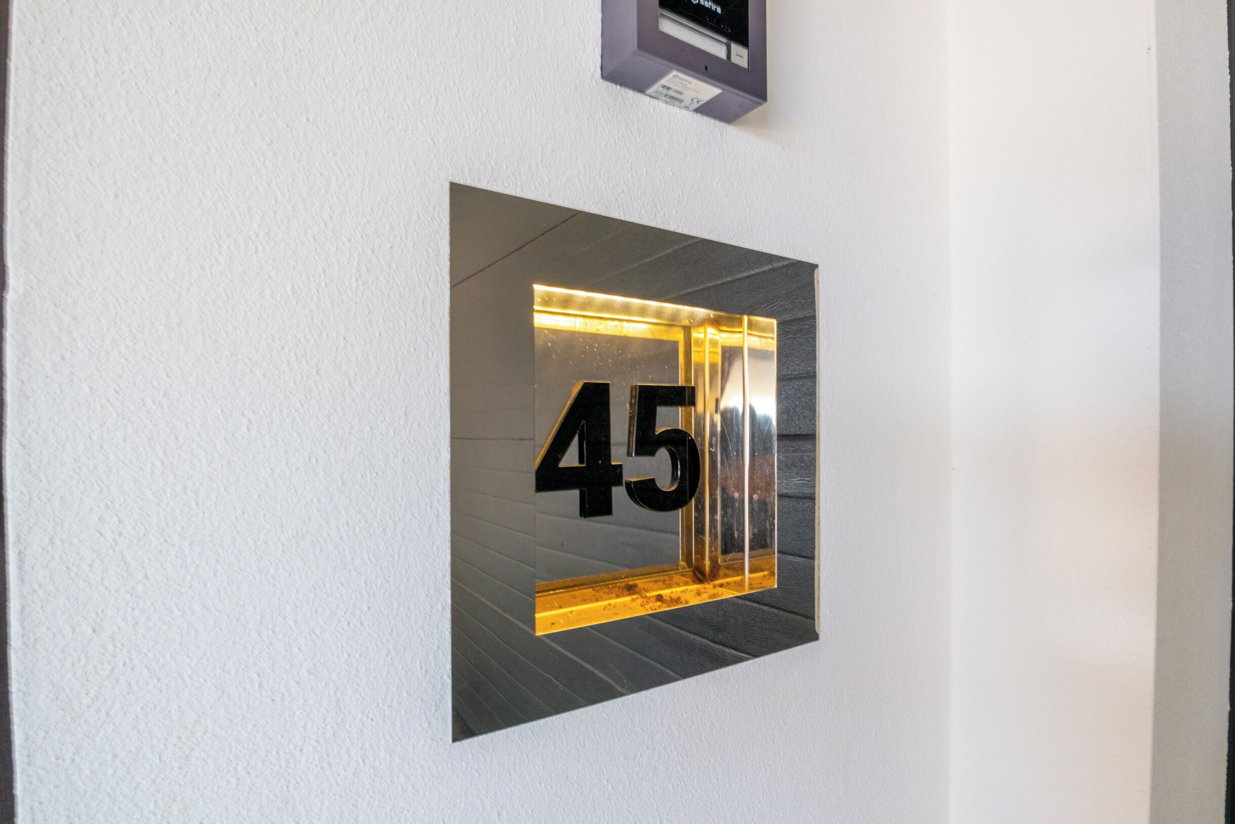 A wall-mounted number sign with the number 45.