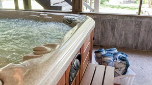 A hot tub with a control panel, surrounded by wooden benches and towels. - Screened-in Hot Tub, Clean, 5 min to LU + Shopping! (Lynchburg)