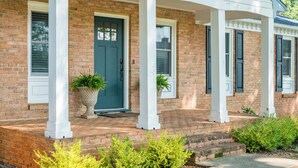 A brick house with a porch, a green door, and white columns. - Screened-in Hot Tub, Clean, 5 min to LU + Shopping! (Lynchburg)