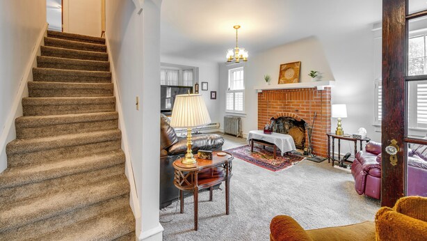 A spacious living room with a fireplace, a staircase, and a cozy seating area. - 8 Mi to Elk Mountain Ski Resort: Clifford Home! (Clifford)