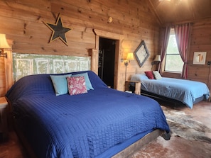 Un dormitorio tipo cabaña de madera con dos camas, una decoración de estrellas y un suelo de madera rústica.