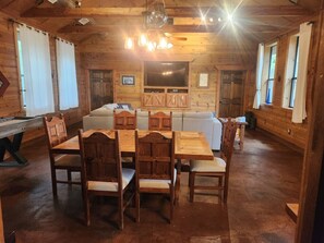 Un interior de madera con una mesa de comedor y sillas, un sofá y una televisión.