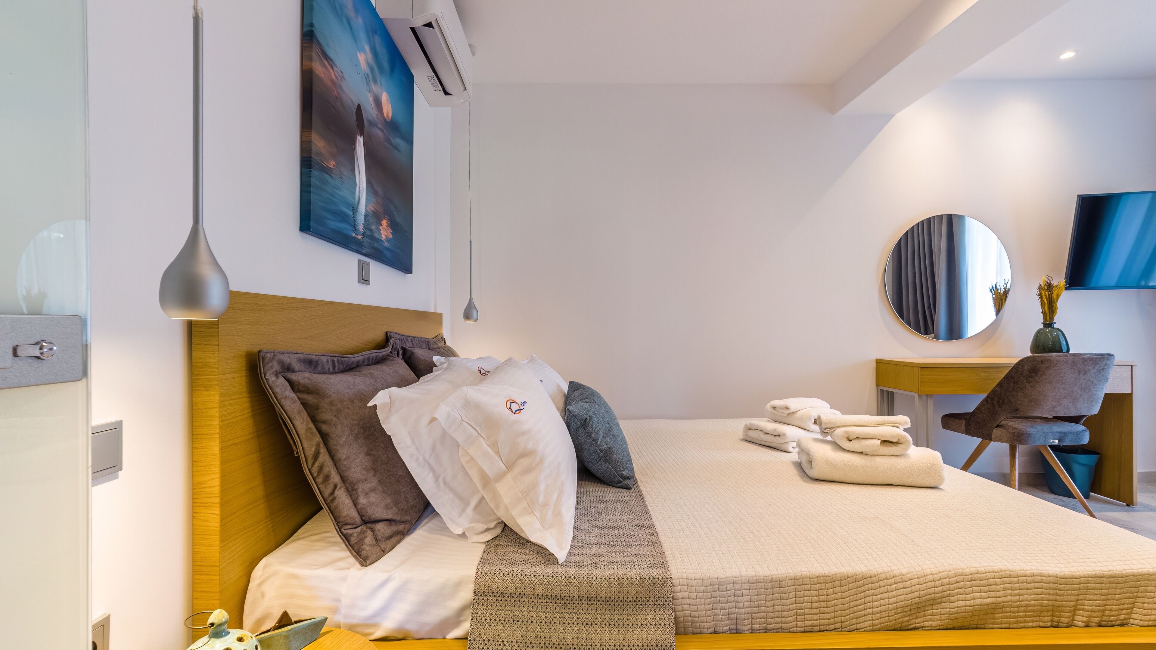 Una habitación de hotel moderna con una cama grande, un escritorio y una silla.