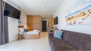 Una habitación de hotel moderna con una cama, un sofá, un televisor y un cuadro.
