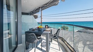 Un balcón con una mesa dispuesta para dos personas, con vistas al mar.