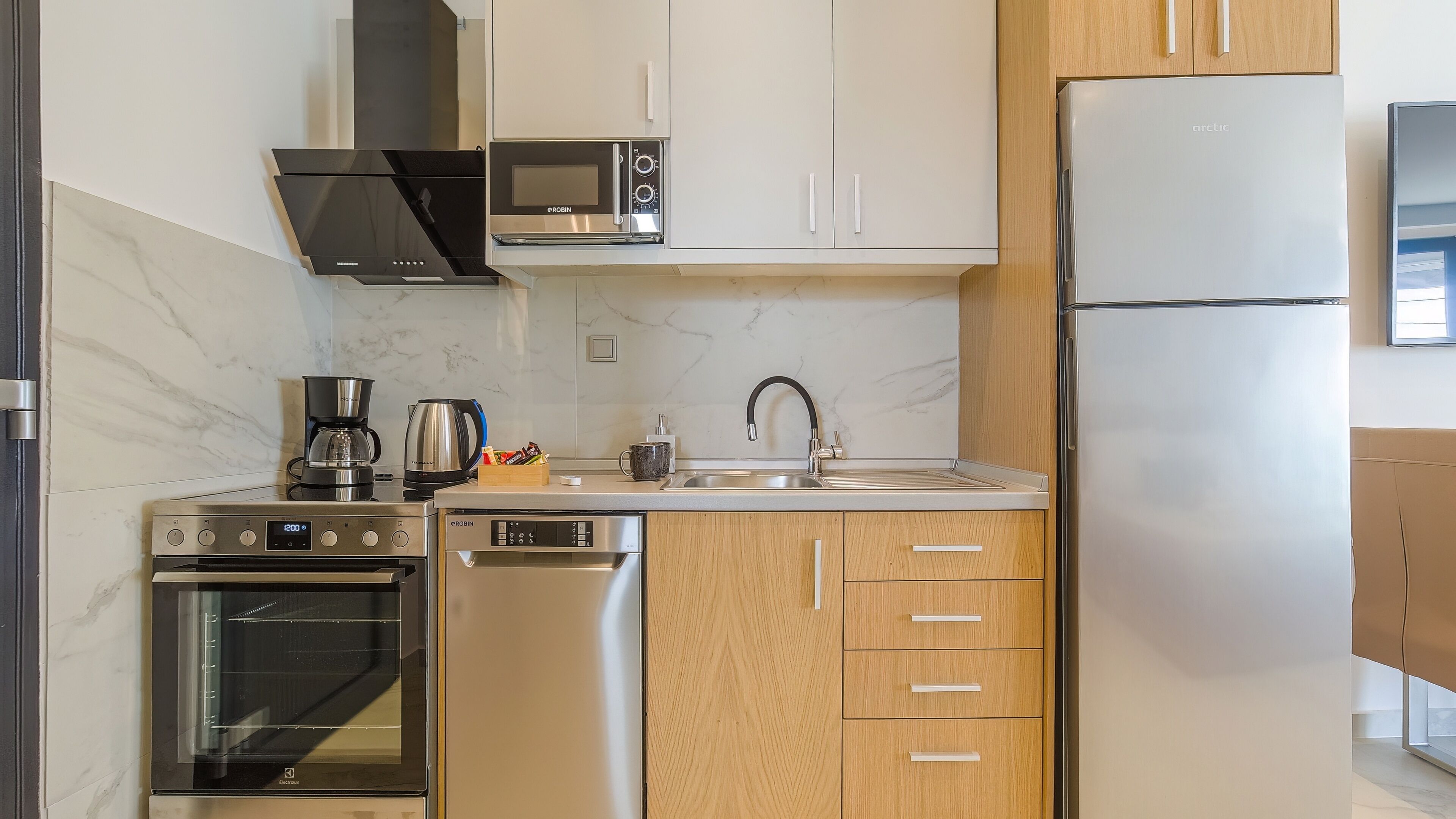 A modern kitchen with stainless steel appliances, a built-in oven, a microwave, and a refrigerator.