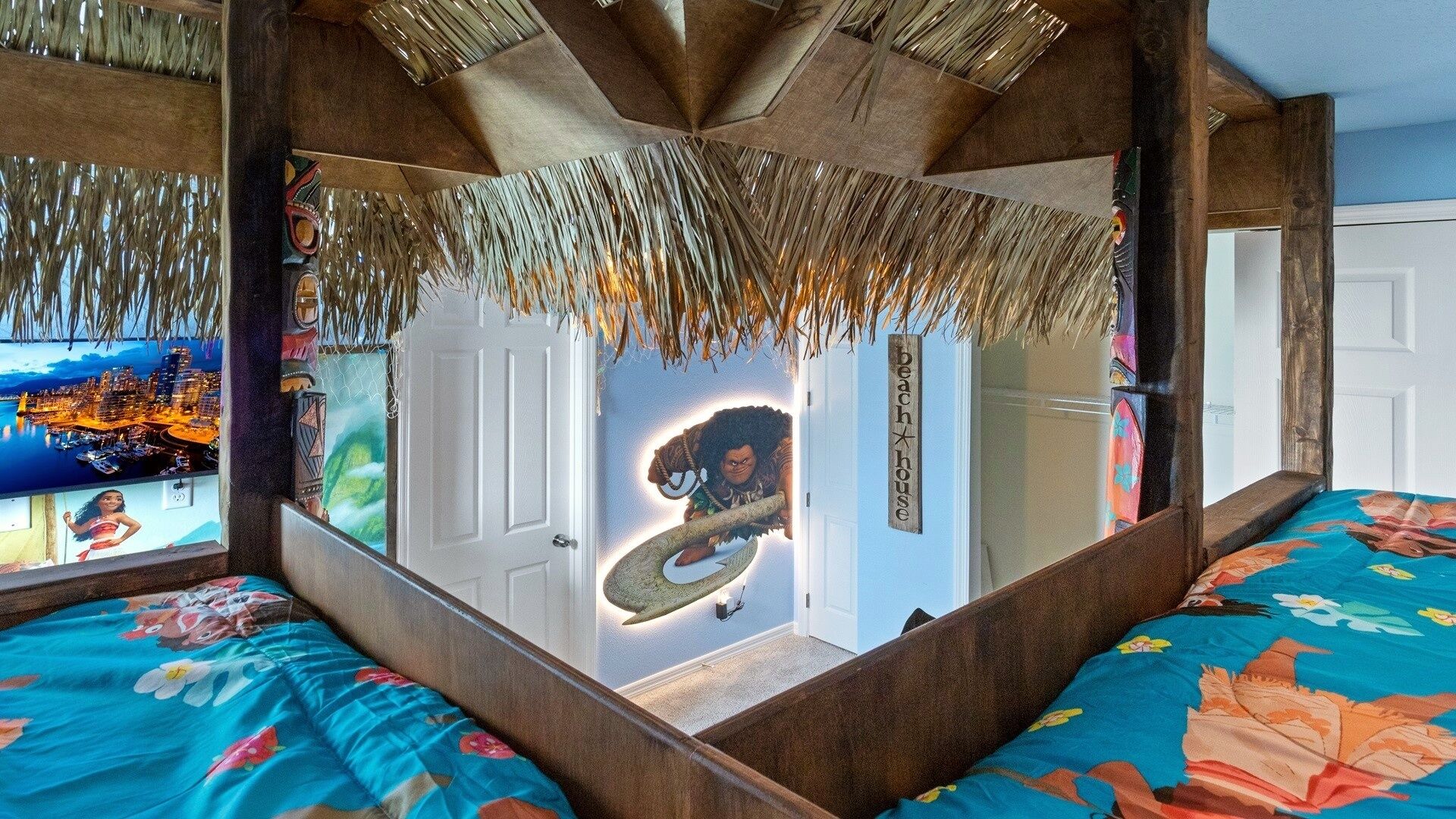 A room with a unique design, featuring a large mirror, a bed with a floral bedspread, and a mural of a cityscape and a character.