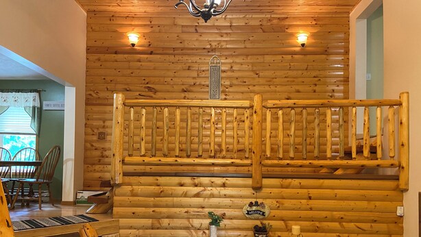 A wooden interior with a staircase, a reception desk, and a dining area. - Hickey Creek Retreat Secluded Log Home - 7 miles from Pictured Rocks Lake shore (Shingleton)