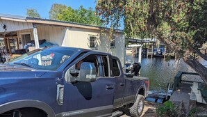 Una camioneta estacionada cerca de un muelle con un bote.