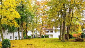 Un quartier résidentiel avec des bâtiments blancs, une pelouse verdoyante et une clôture en bois.