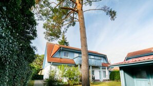 A two-story house with a red-tiled roof, a visible front porch, and a pathway leading to the entrance. - Apartment Jacobs by Interhome (Zinnowitz)