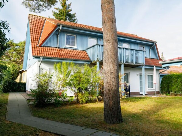 A two-story house with a red-tiled roof, a balcony, and a well-maintained lawn. - Apartment Jacobs by Interhome (Zinnowitz)