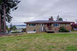 A single-story house with a front porch, a garage, and a view of the water.