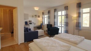 A hotel room with a bed, a desk with a computer, a chair, and a TV. - App.17 Zinnowitzer Hof by Interhome (Zinnowitz)