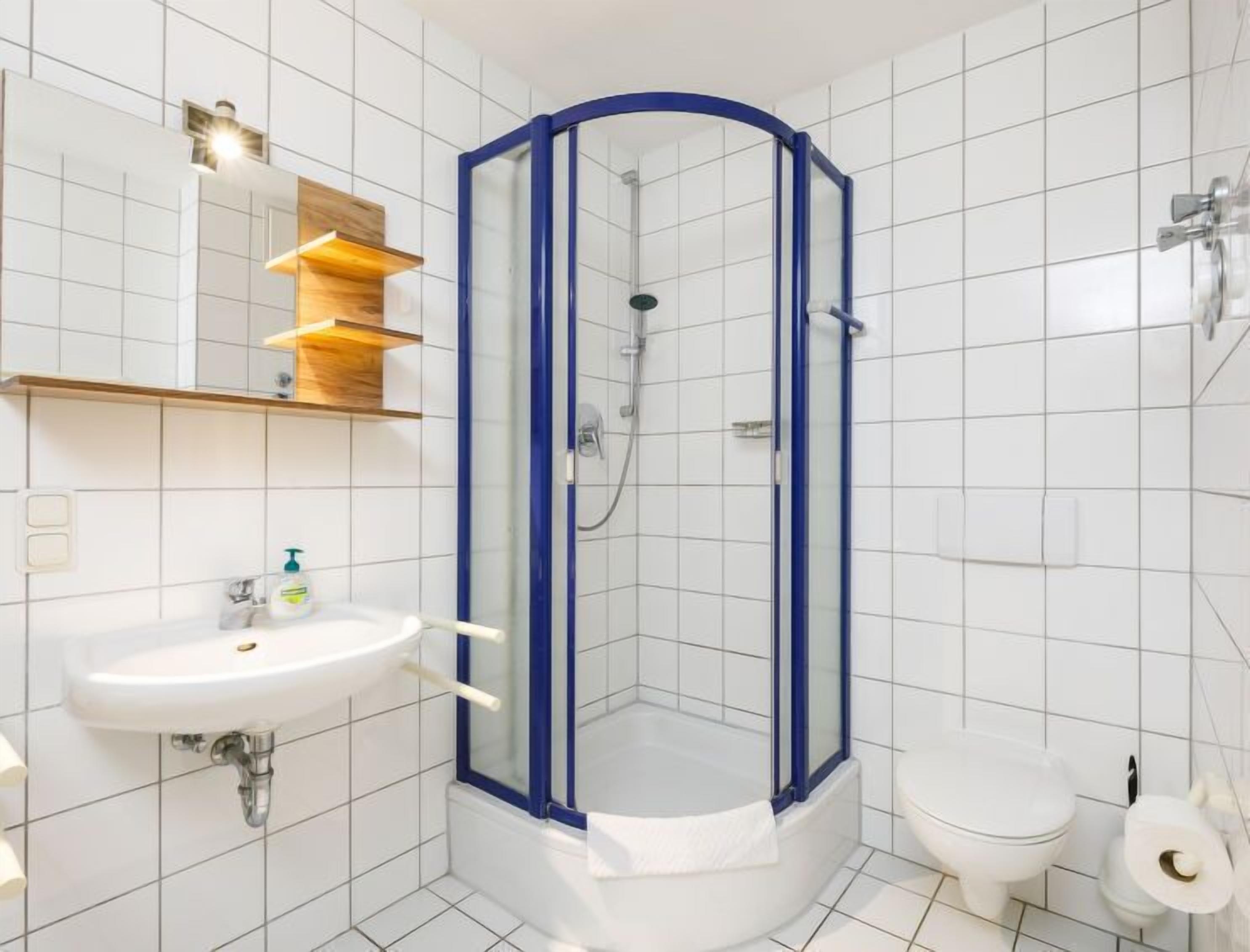 Ein Badezimmer mit Waschbecken, Toilette und einer Duschkabine.