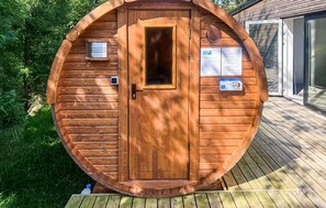 A wooden cabin with a door, a window, and a small outdoor area with a wooden deck.